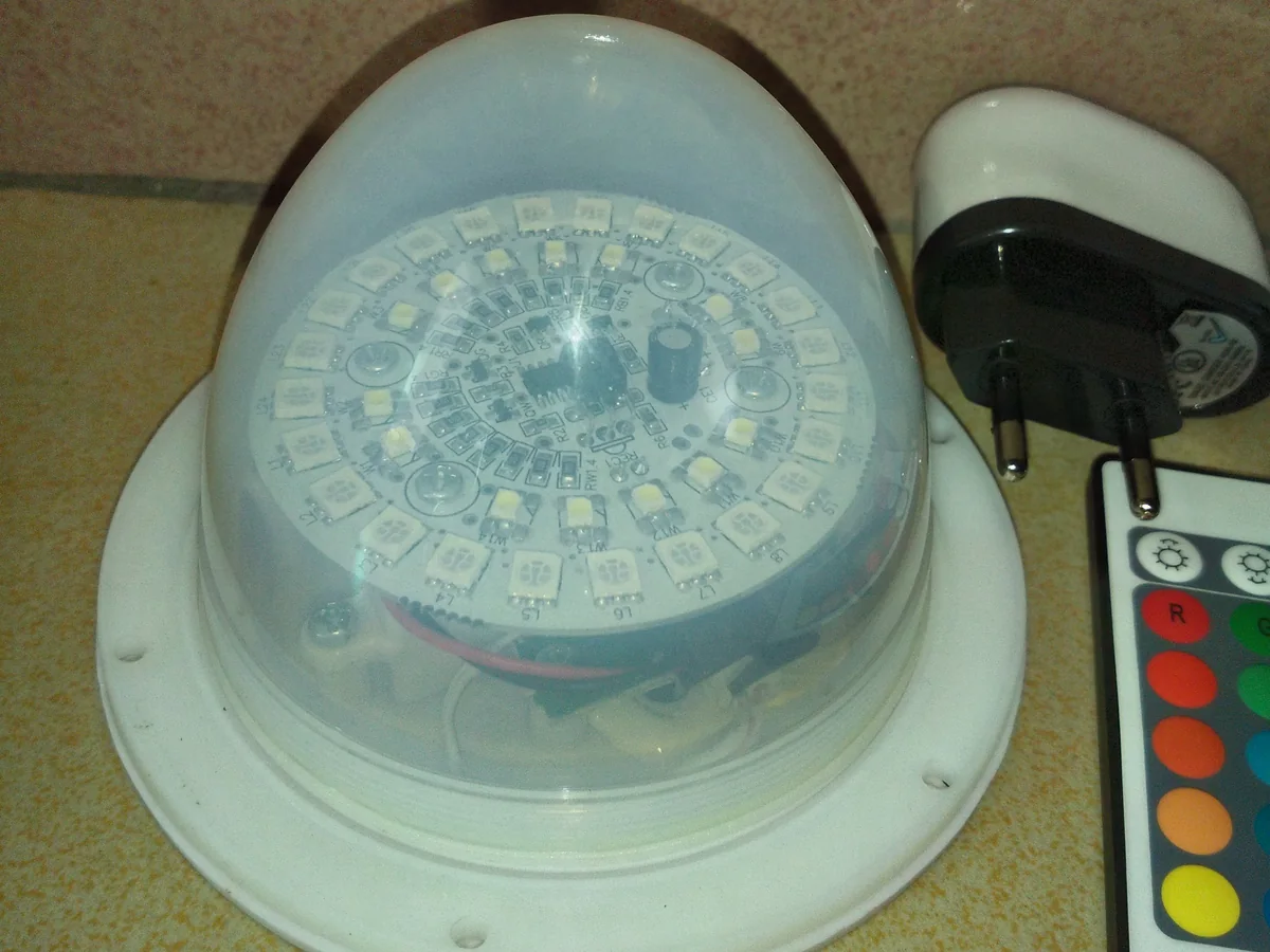Archived rechargeable RGB LED light with visible circuit board, charger and remote control