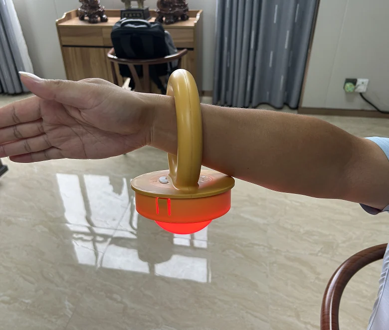 Finished ring-handle LED module sample illuminated red while supported on an arm