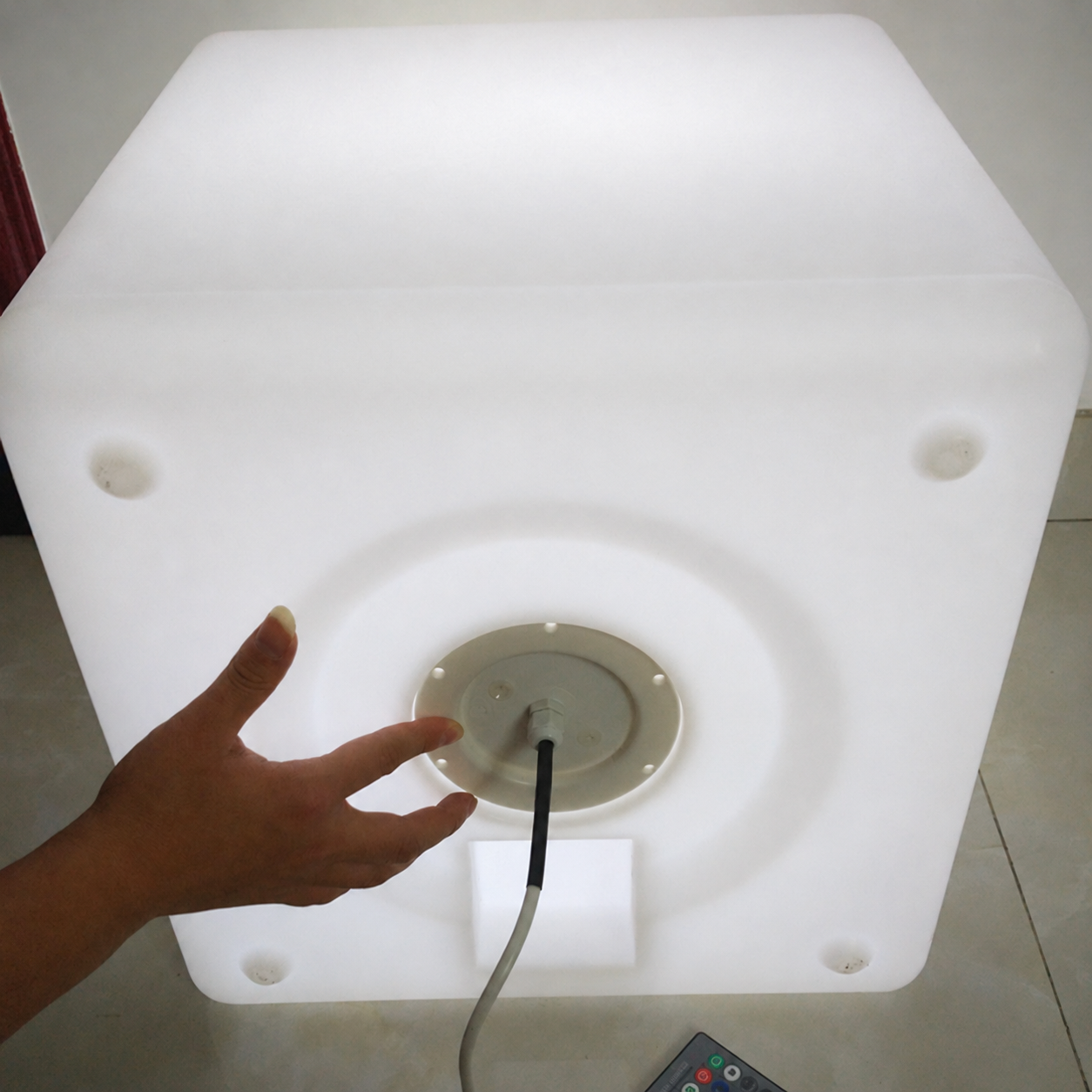 Round E27 light base mounted into the underside opening of illuminated PE cube furniture