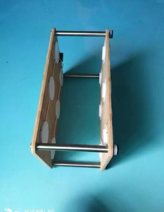 Side view of a custom charging-board assembly showing two wooden panels joined by metal support rods