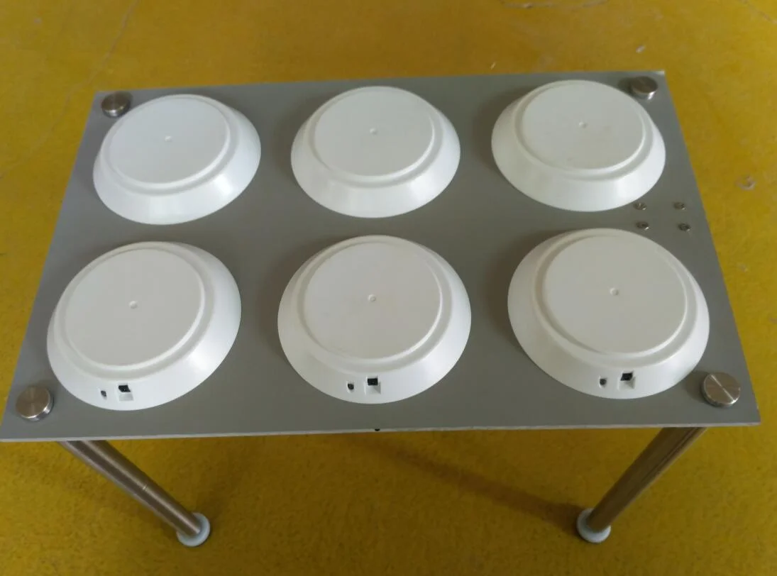 Raised metal platform carrying six circular charging positions in two rows