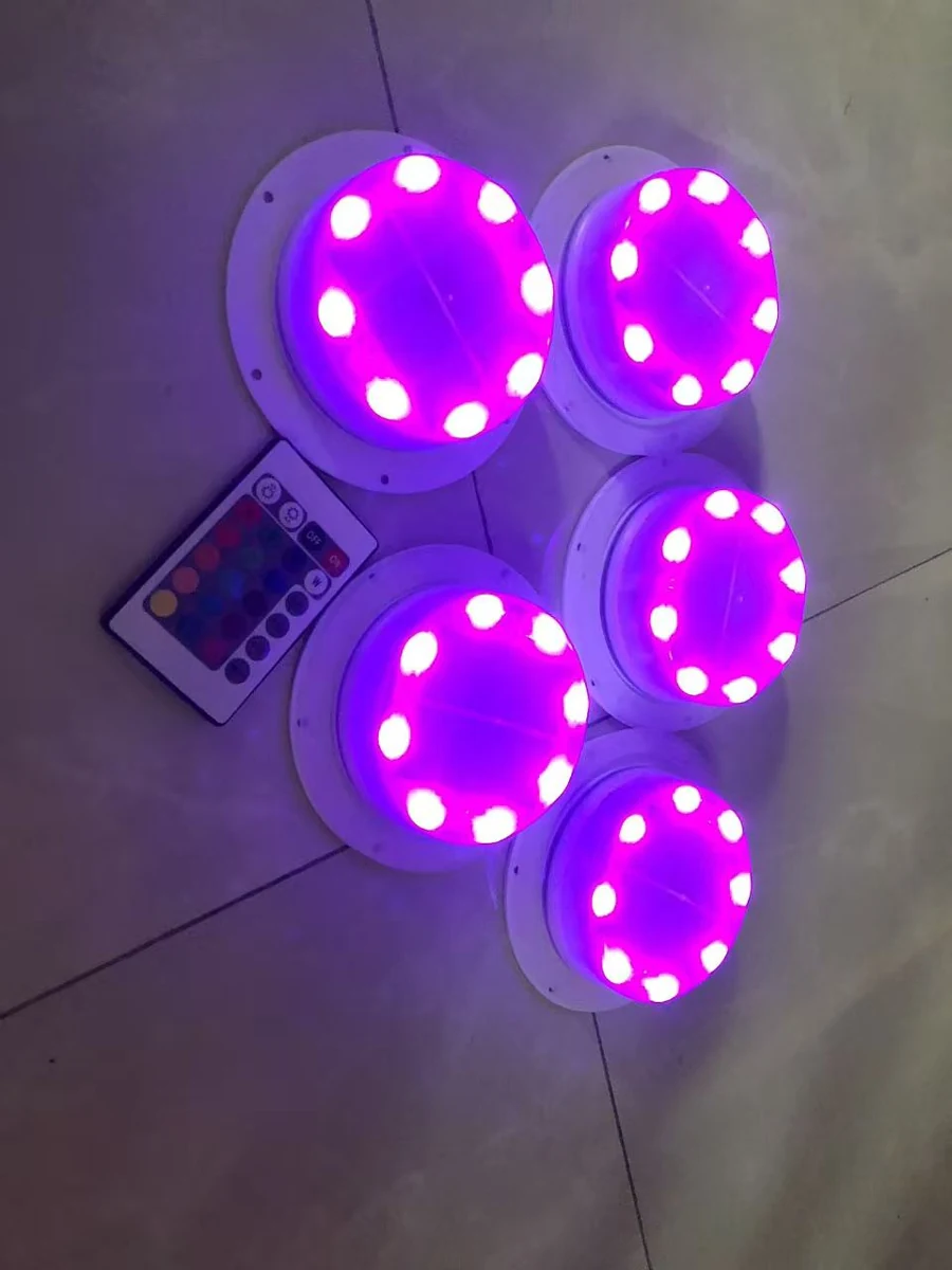 Five solar LED modules displaying purple light beside a handheld remote in a Vcan product photograph