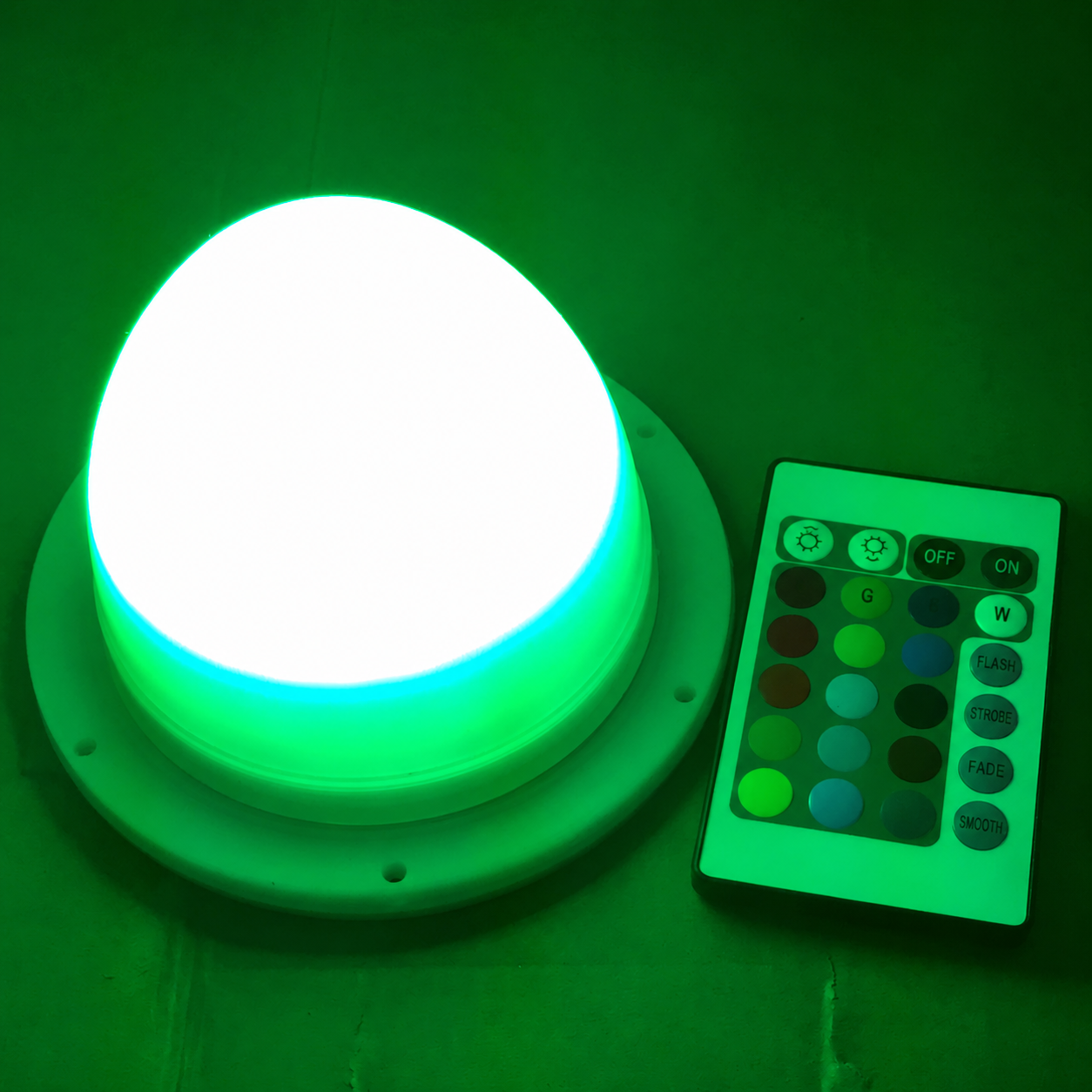 Archived VC-L120 RGB replacement light illuminated green beside its remote control